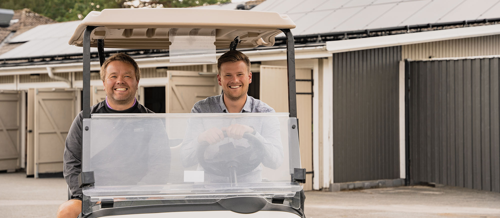 Kristian och Tobias sitter i en golfbil