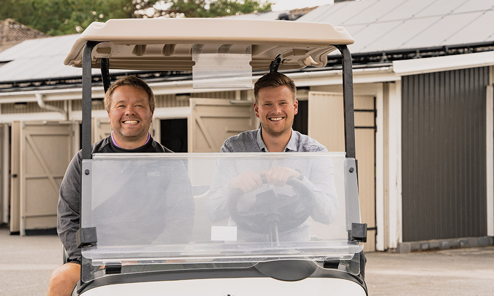 Kristian och Tobias sitter i en golfbil
