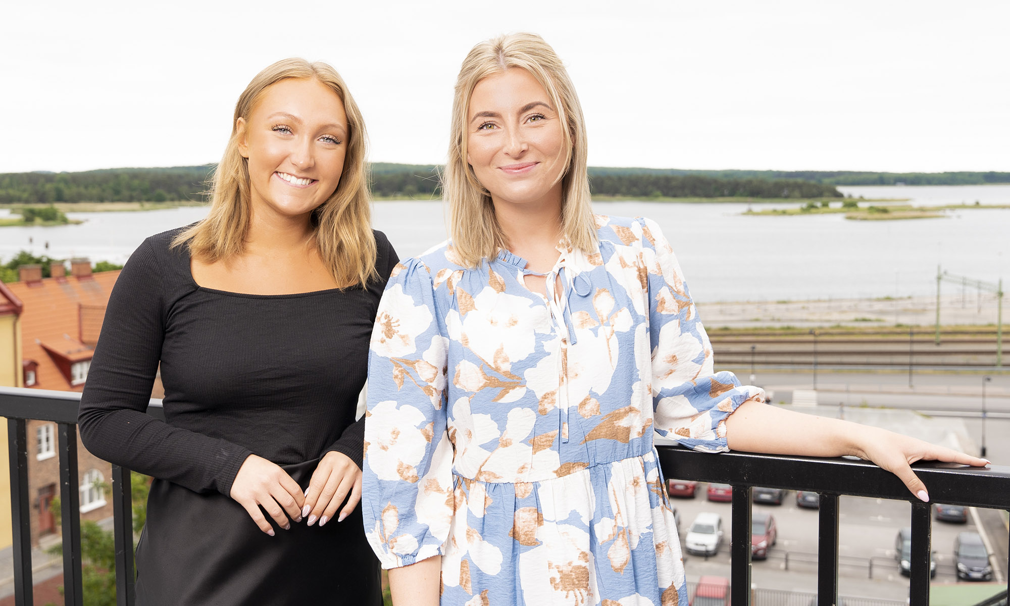 Våra kundvärdar Tindra och Emma står på balkongen med Sölvesborgsviken i bakgrunden.
