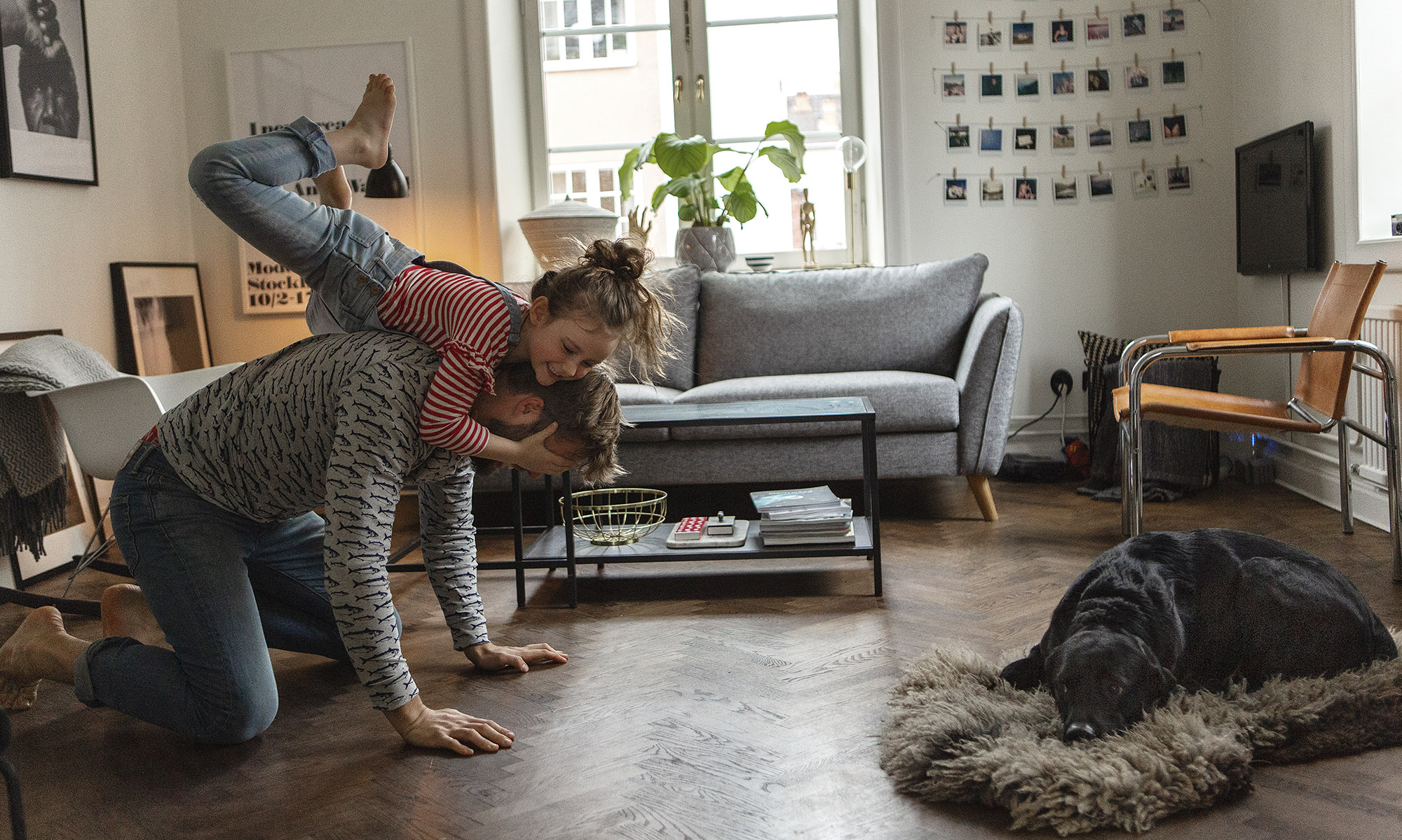 Pappa och dotter leker i ett vardagsrum